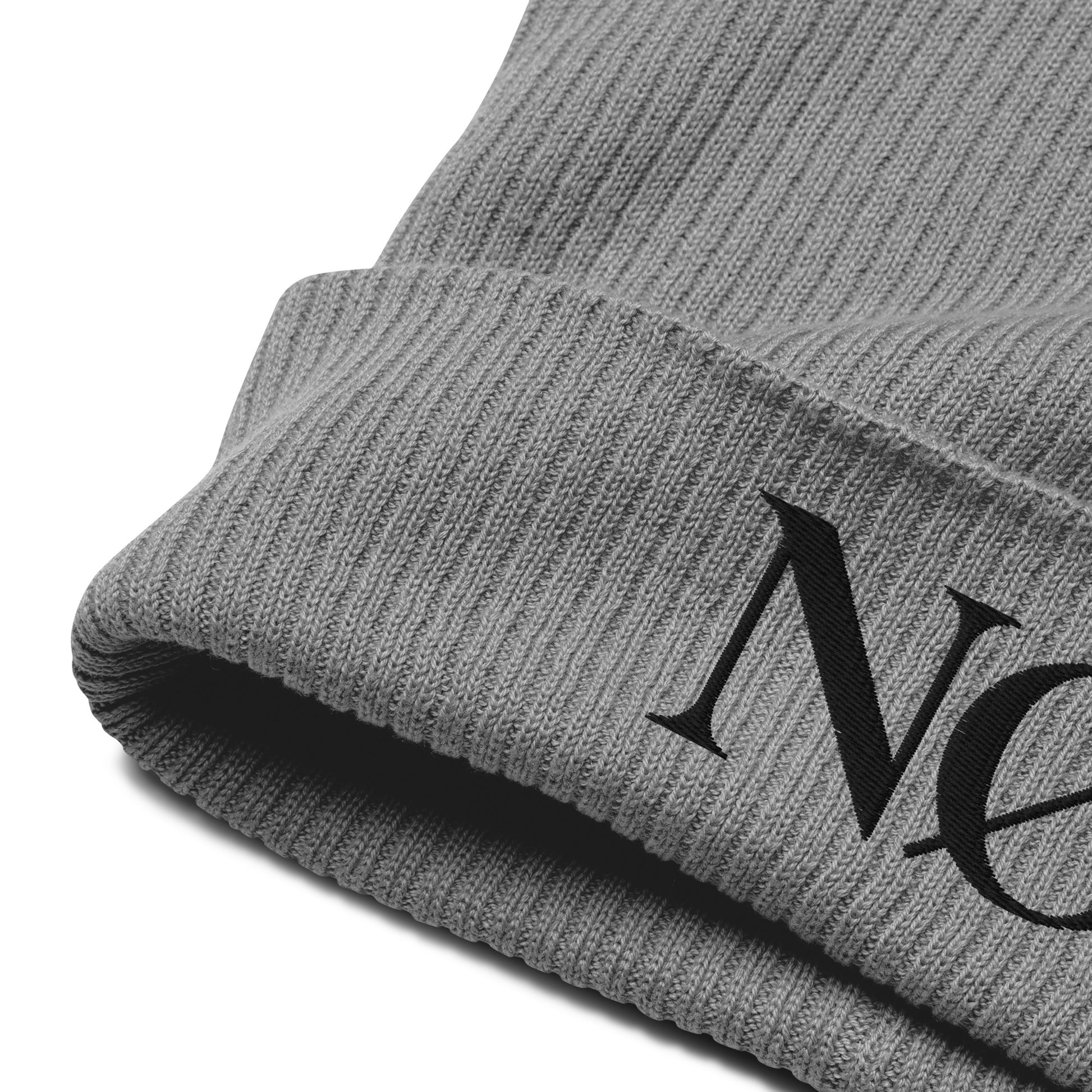 Close-up of the minimalist, ribbed-knit beanie by Nørvael in light grey. The "NØ" logo is subtly embroidered in black.
