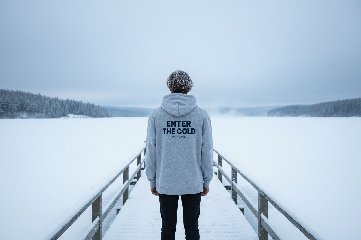 The "Enter The Cold" ritual hoodie by Nørvael. This grey hoodie features the signature mantra printed in white across the back.