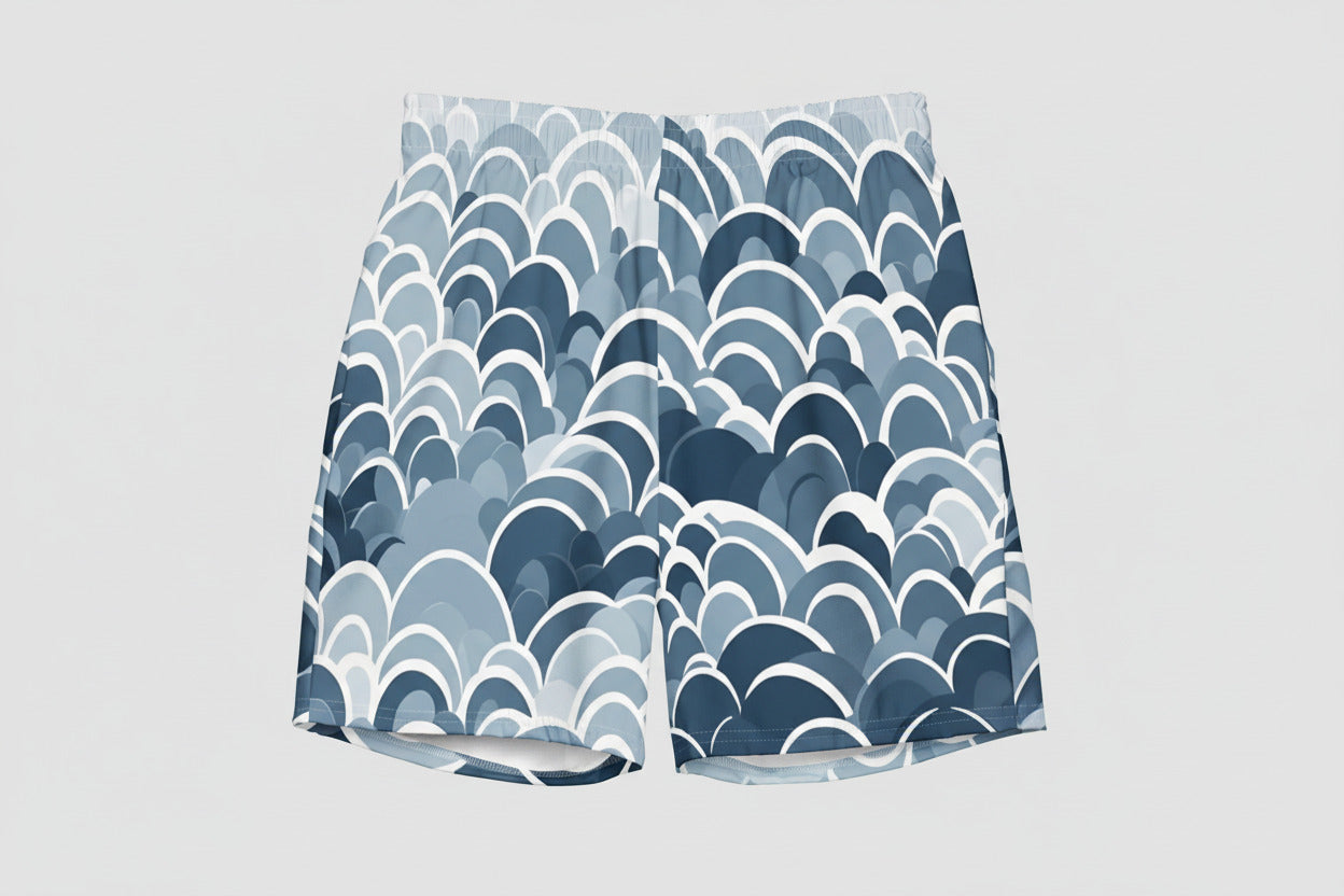 Men's blue geometric swim shorts with abstract wave pattern in light blue and navy, modern above-the-knee fit