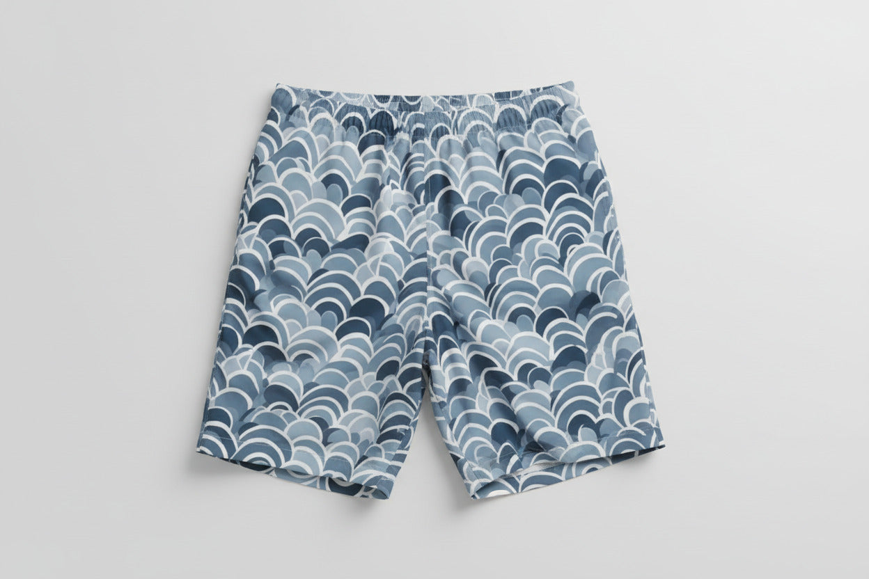 Modern men's swim shorts with abstract ocean-inspired geometric print in cool blue tones"